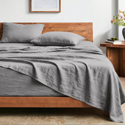 Bed with washed sheets and wooden headboard in a bedroom setting