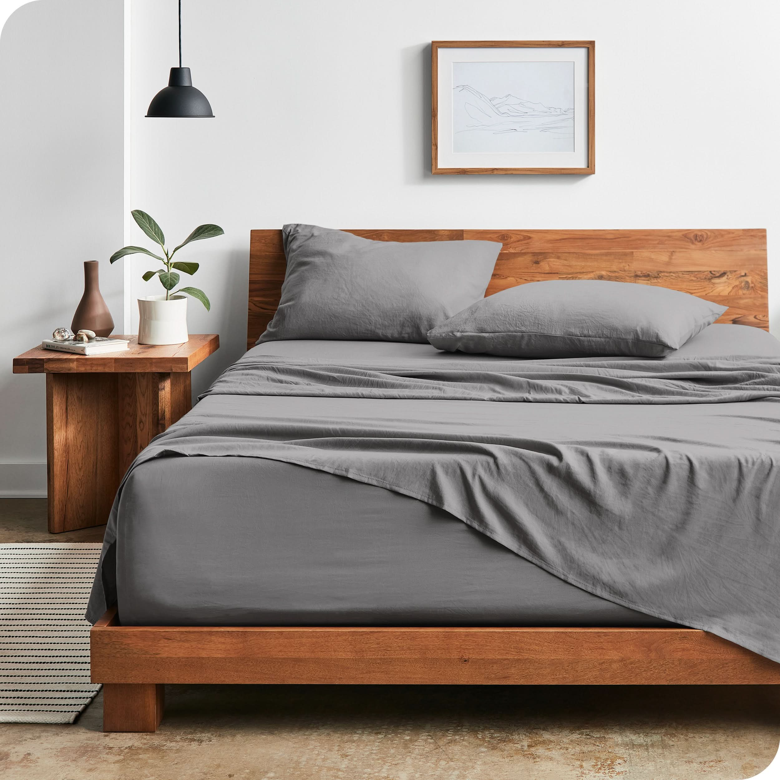 Modern bedroom with sandwashed sheets draped over the end and the side of the bed