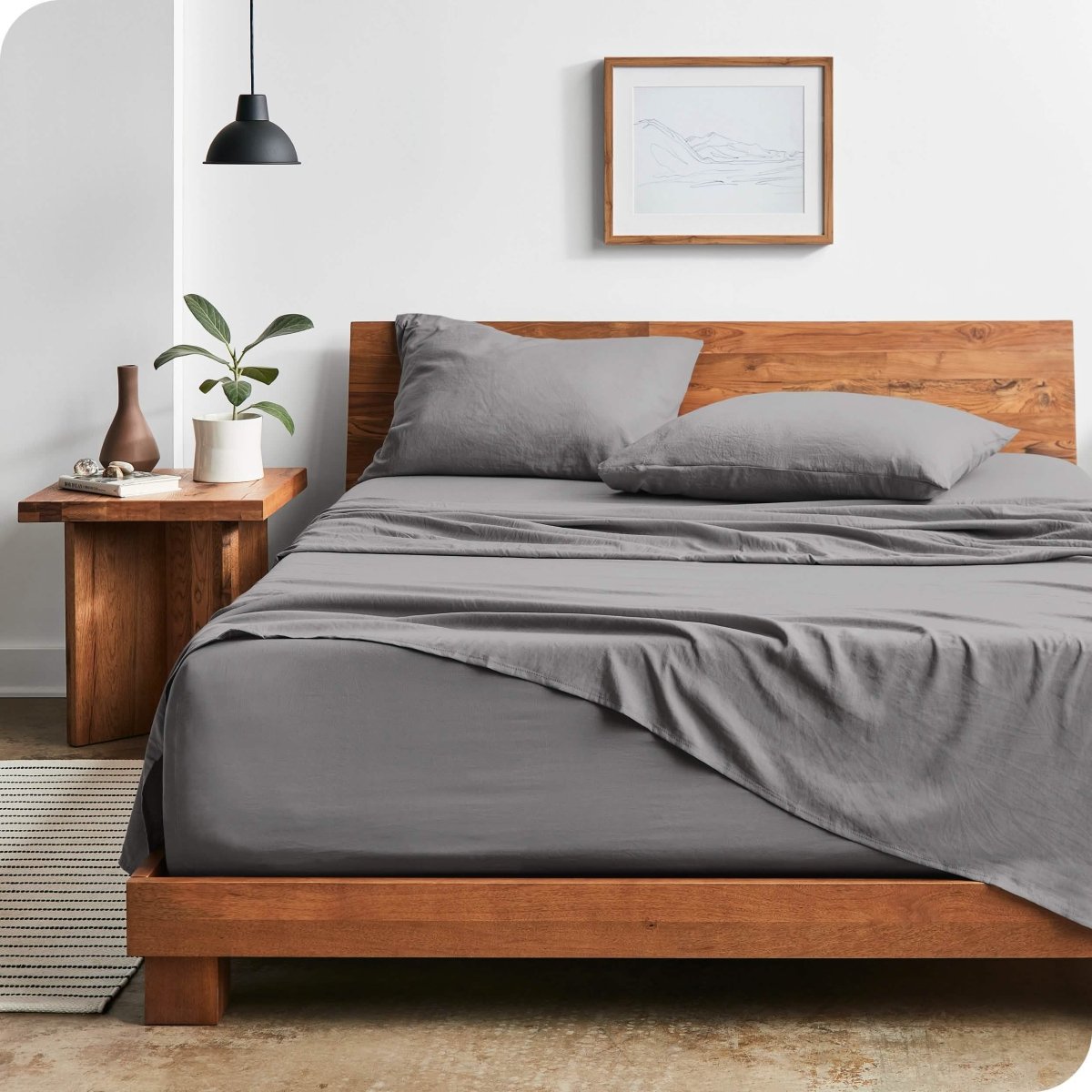 Modern bedroom with washed sheets draped over the end and the side of the bed