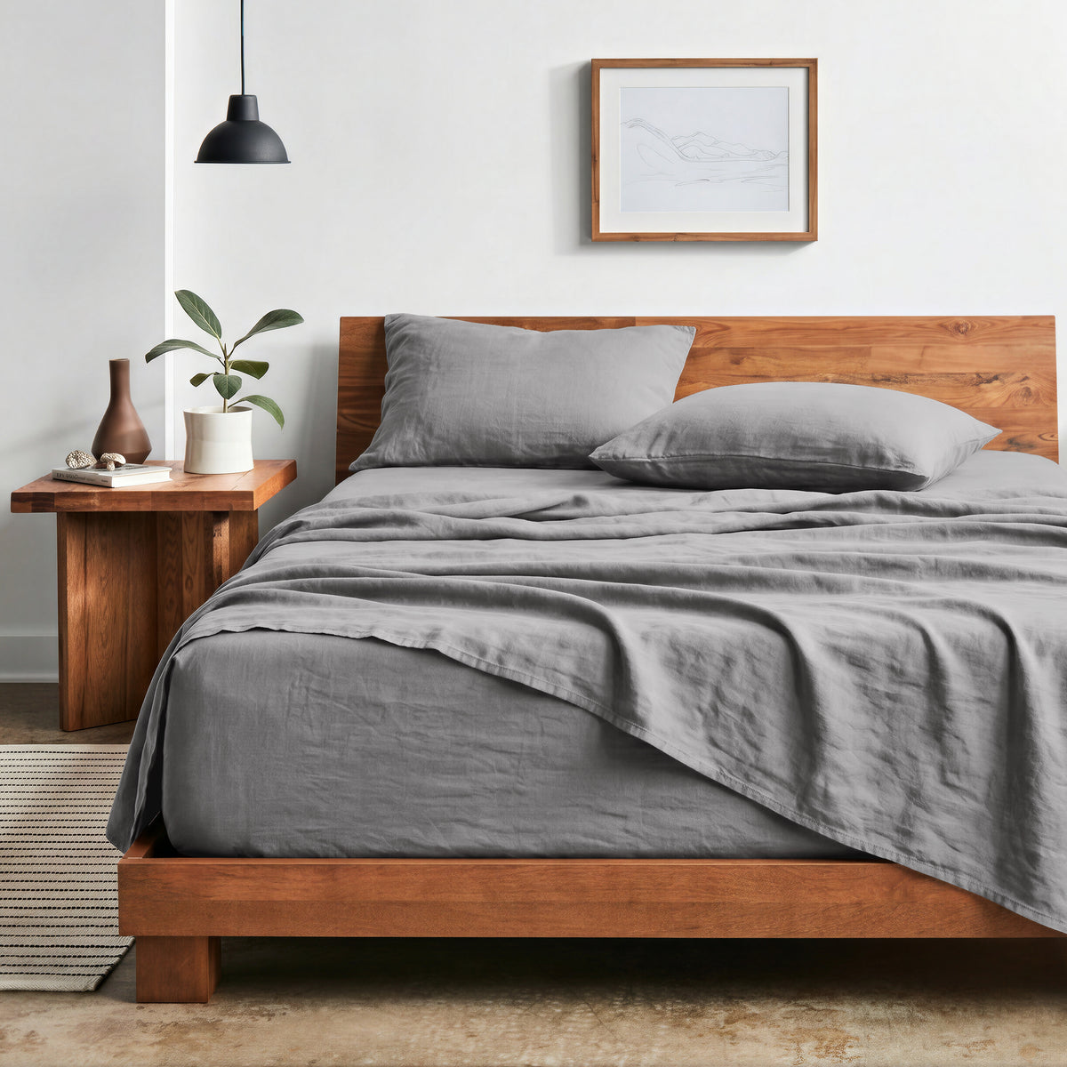 Bedroom with sheet set on a wooden bed frame and side table