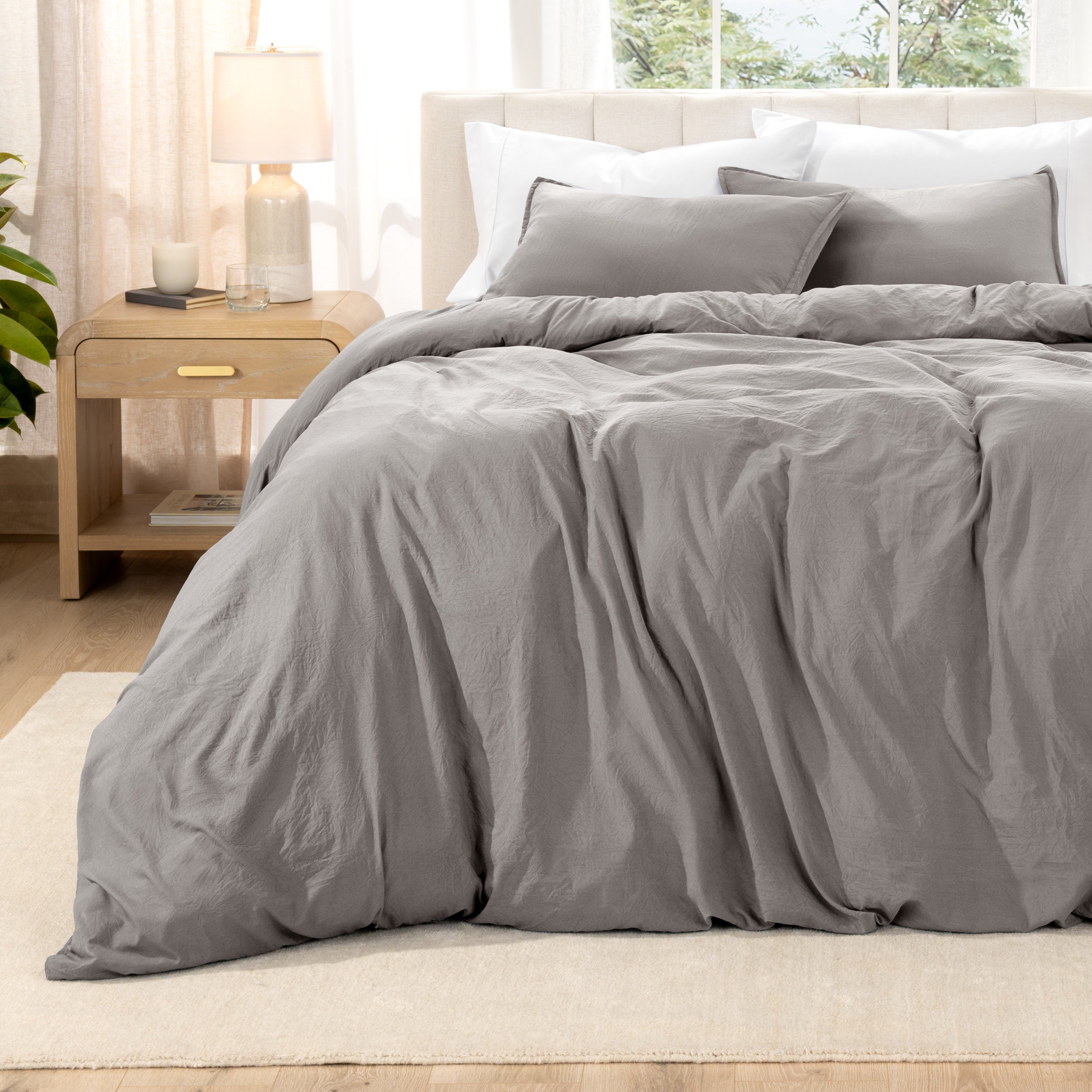 Washed bedding set on a bed with a nightstand in the background