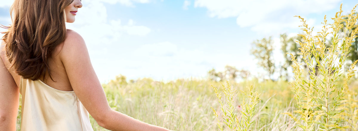 Woman walking in open field in summer
