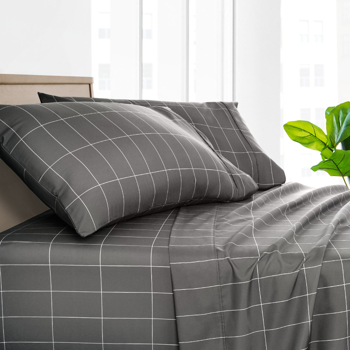 Dark gray bedding set with a grid pattern in a bright bedroom setting.