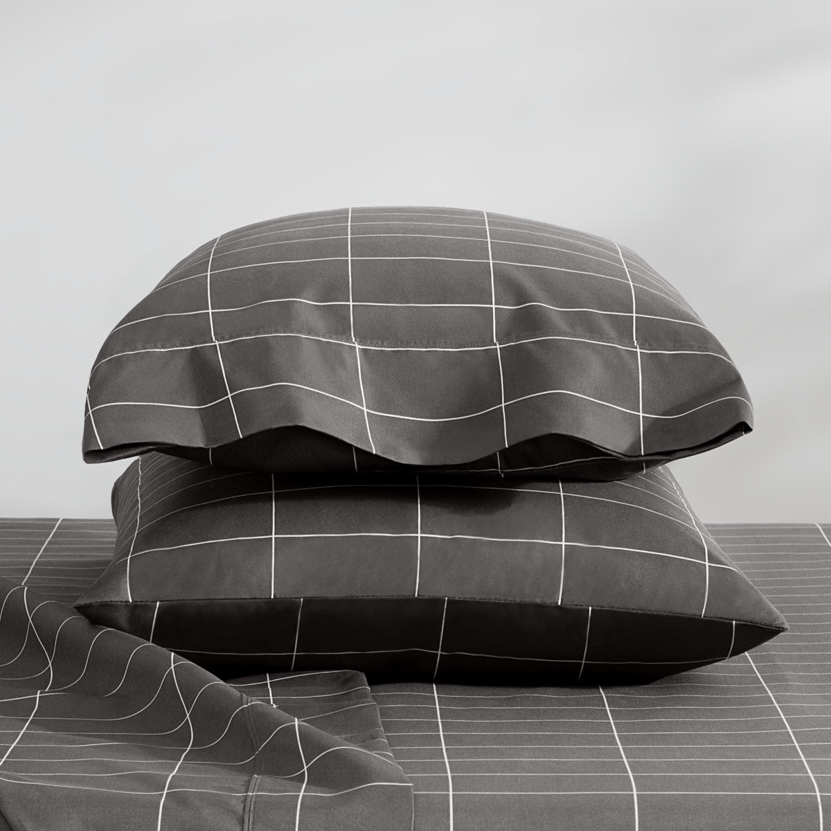 Two stacked pillowcases on a bed