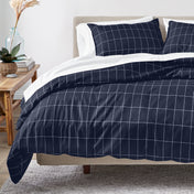 Navy blue grid duvet cover set on a bed in a bedroom setting.