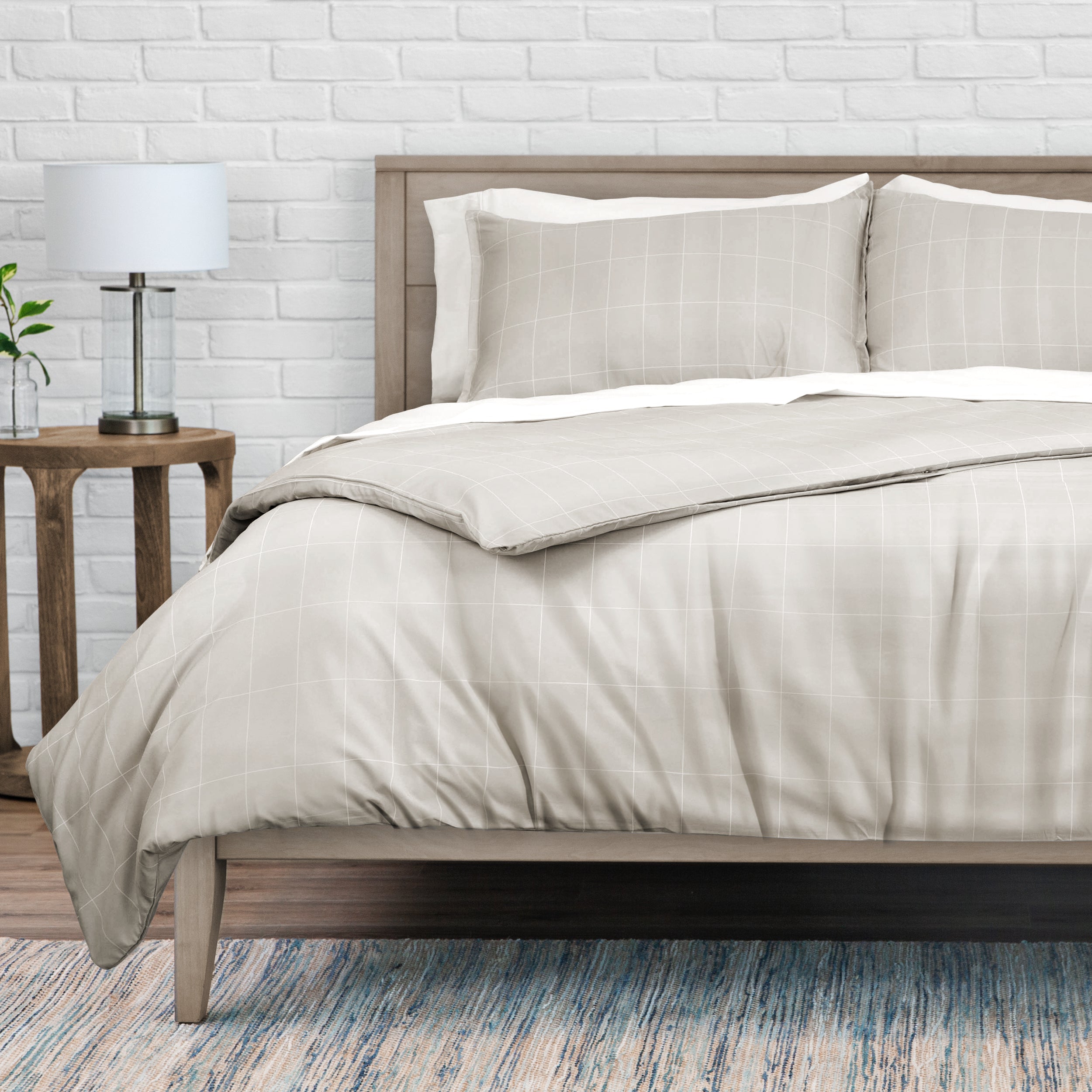 Neatly made bed with beige bedding in a bedroom setting.