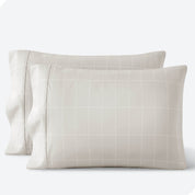 Two pillows on a white background with print pillowcases on them