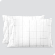 Two pillows on a white background with print pillowcases on them