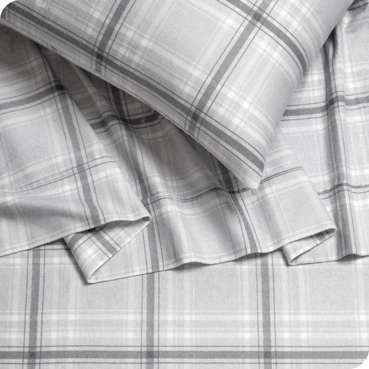 Close up of a pillowcase, top sheet and fitted sheet which are all matching plaid