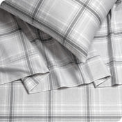 Close up of a pillowcase, top sheet and fitted sheet which are all matching plaid