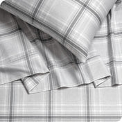 Close up of a pillowcase, top sheet and fitted sheet which are all matching plaid
