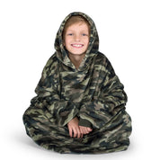 A boy is sitting while in a microplush wearable blanket.