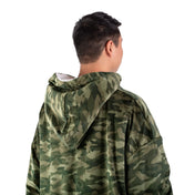 An adult with a hooded wearable blanket on