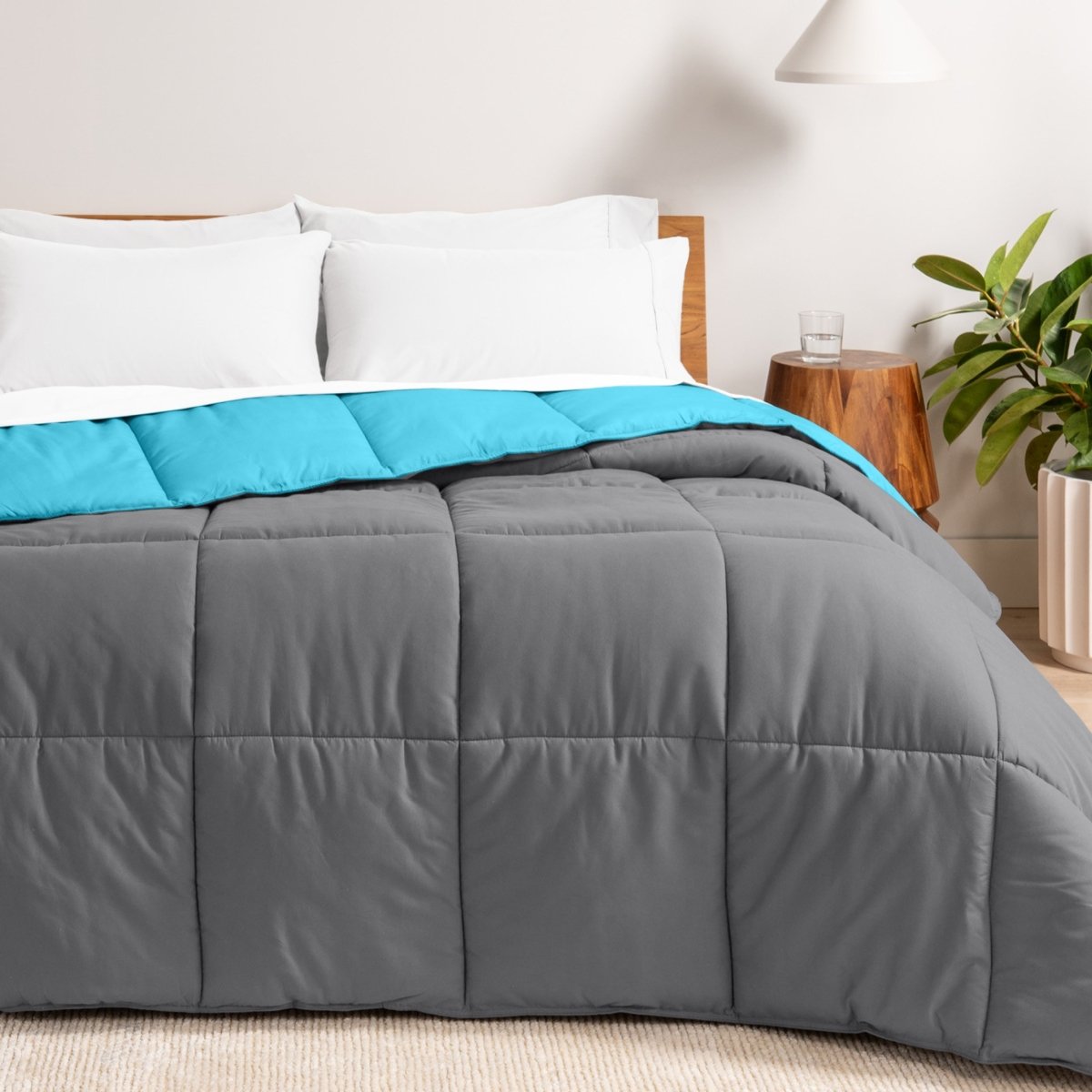 Bed with reversible comforter and white pillows in a bedroom setting