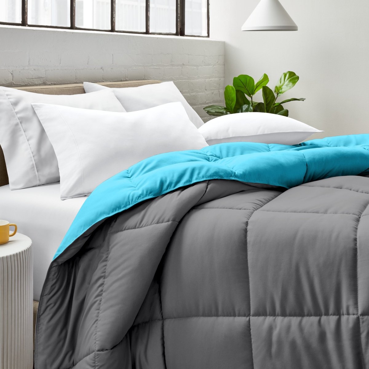 Bed with comforter and white pillows in a bright bedroom setting.