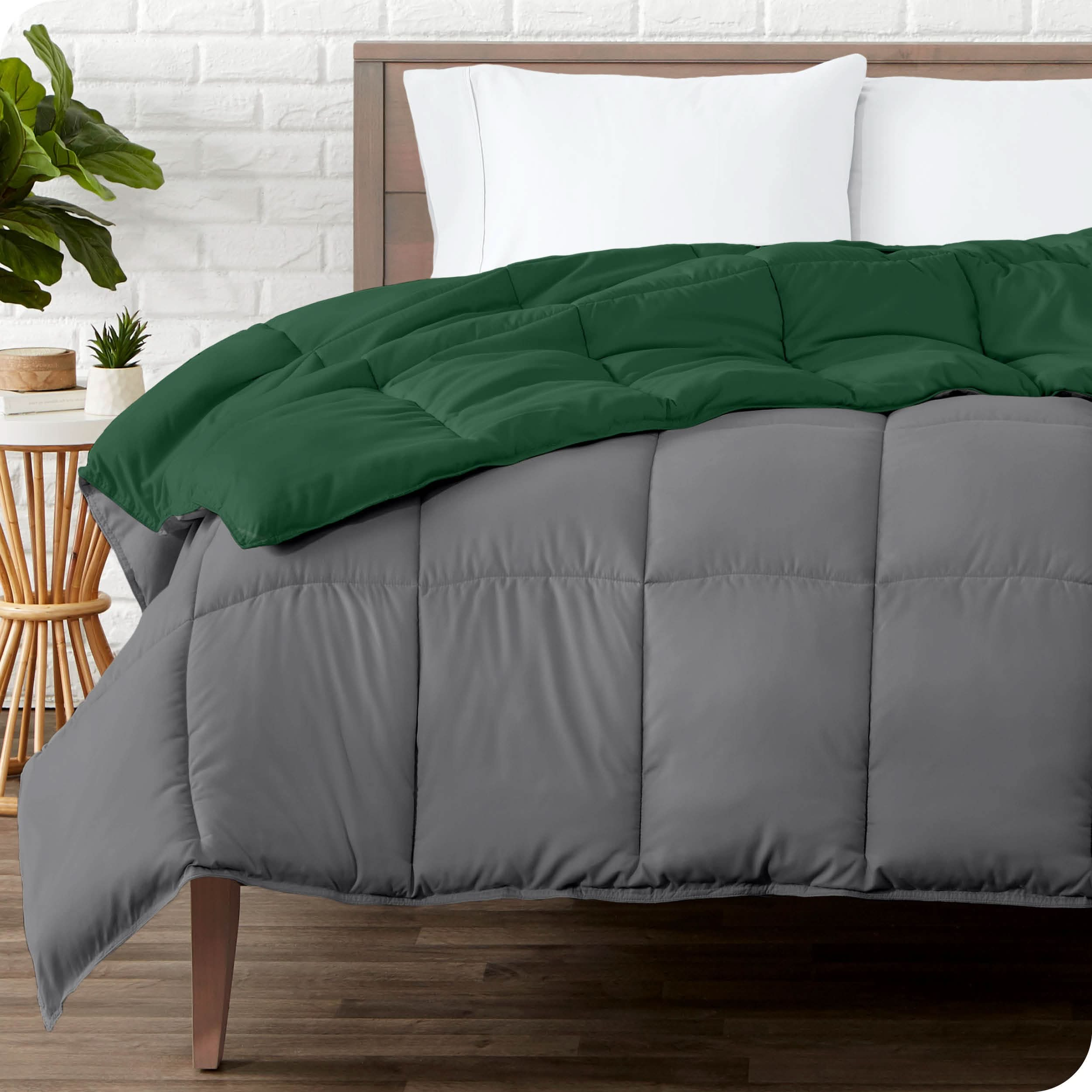 Wooden bed frame with a reversible comforter on the mattress. The comforter is folded back showing the two different colored sides.