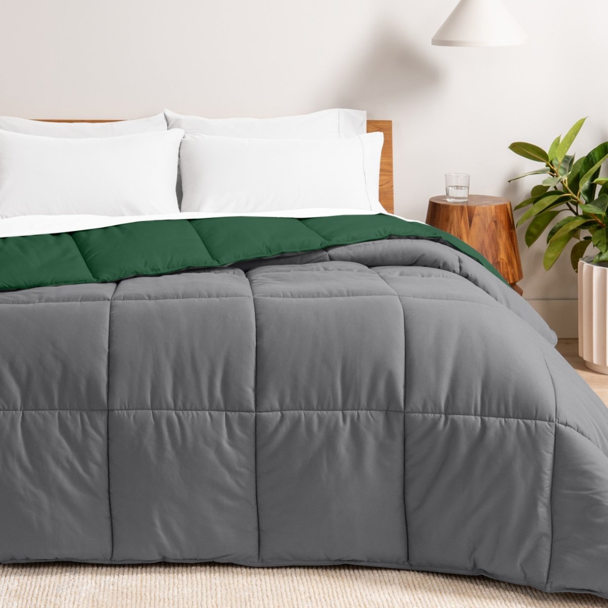 Bed with reversible comforter and white pillows in a bedroom setting