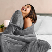 A woman smiling while wrapped in a sherpa blanket