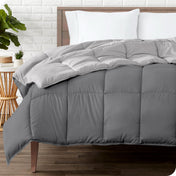 Wooden bed frame with a reversible comforter on the mattress. The comforter is folded back showing the two different colored sides.