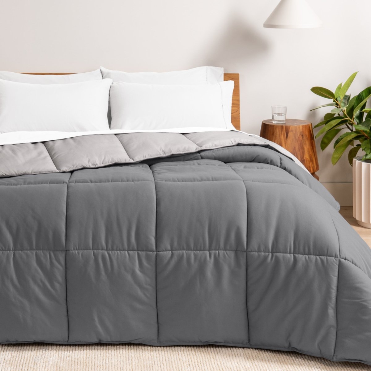 Bed with reversible comforter and white pillows in a bedroom setting