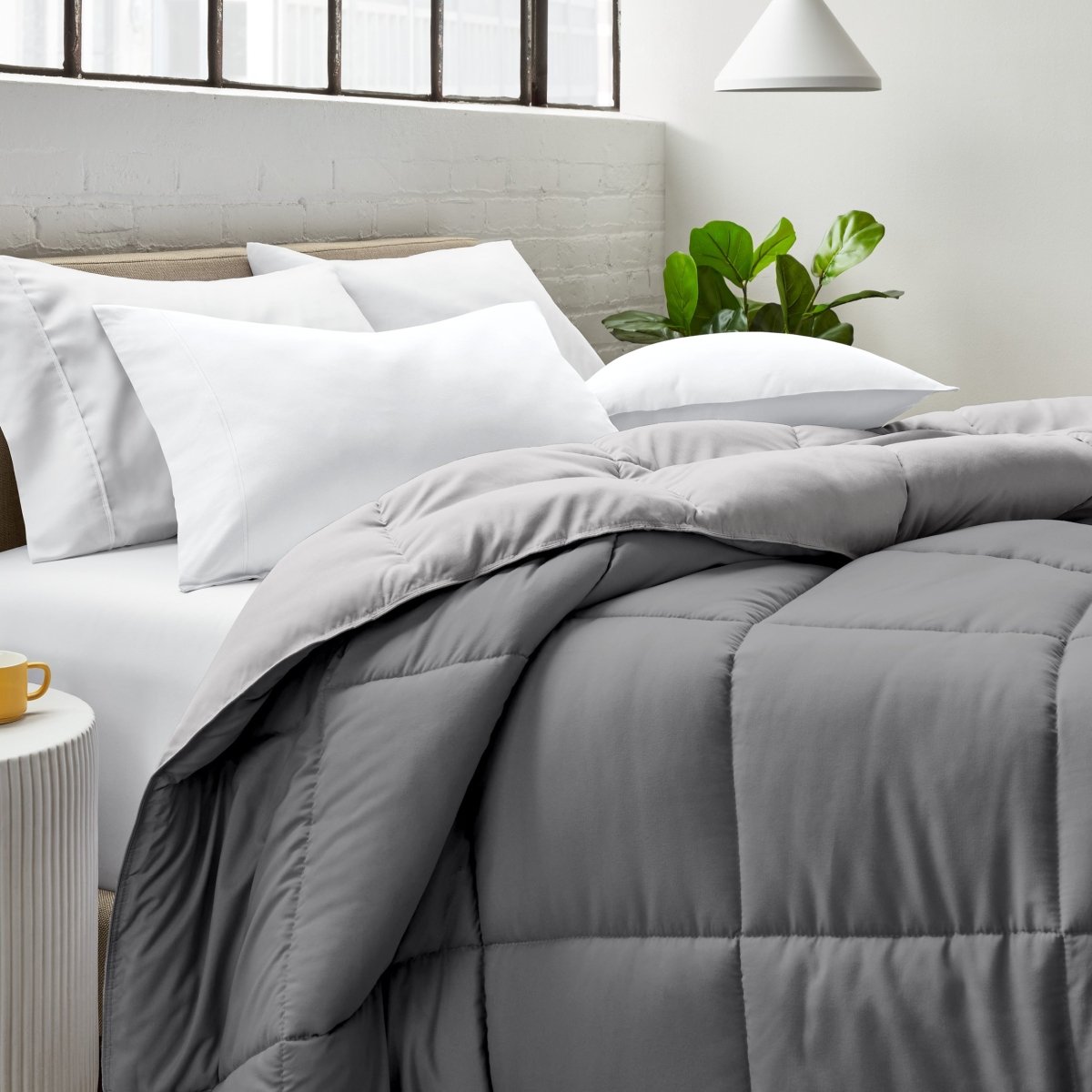 Bed with comforter and white pillows in a bright bedroom setting.