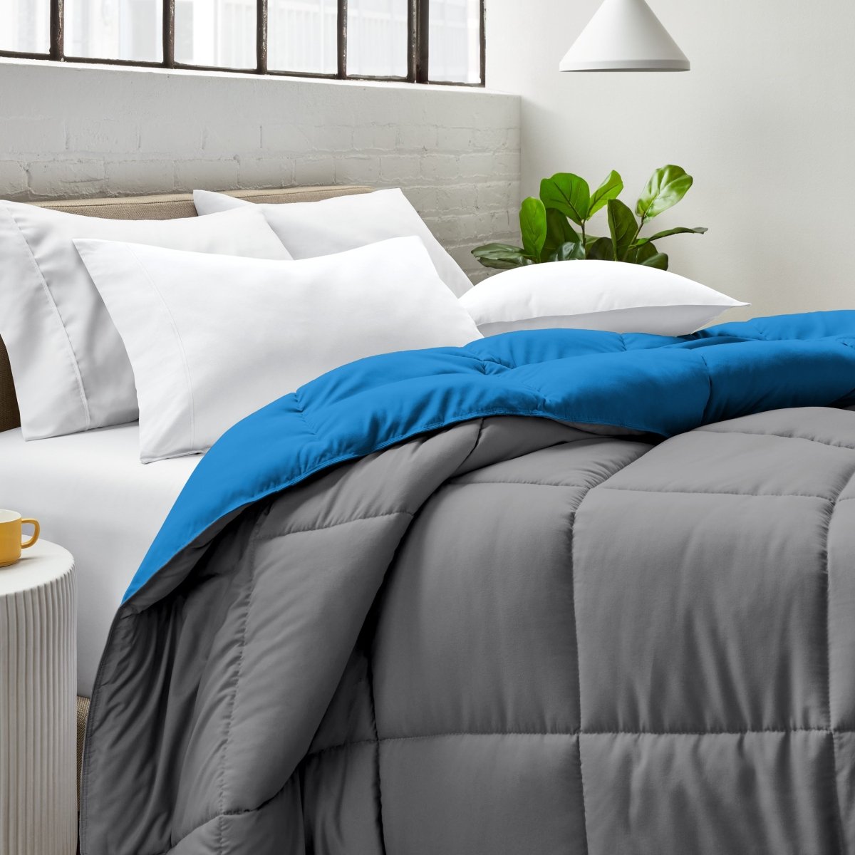 Bed with comforter and white pillows in a bright bedroom setting.