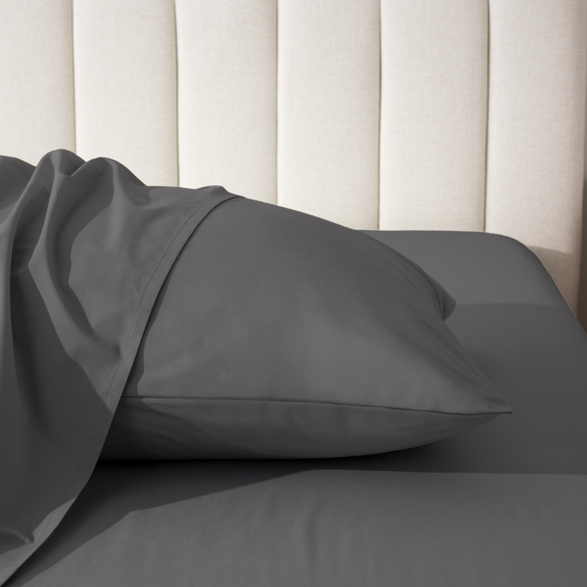 Pillow on a bed with a neutral headboard