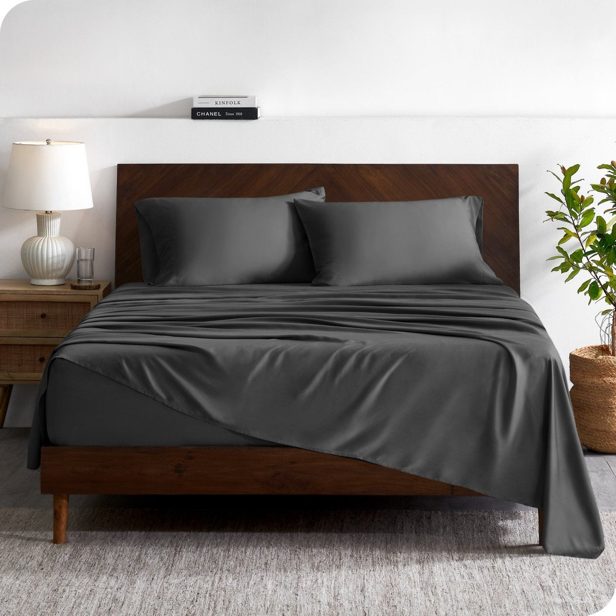 A contemporary bed with a sheet set and a wooden headboard.