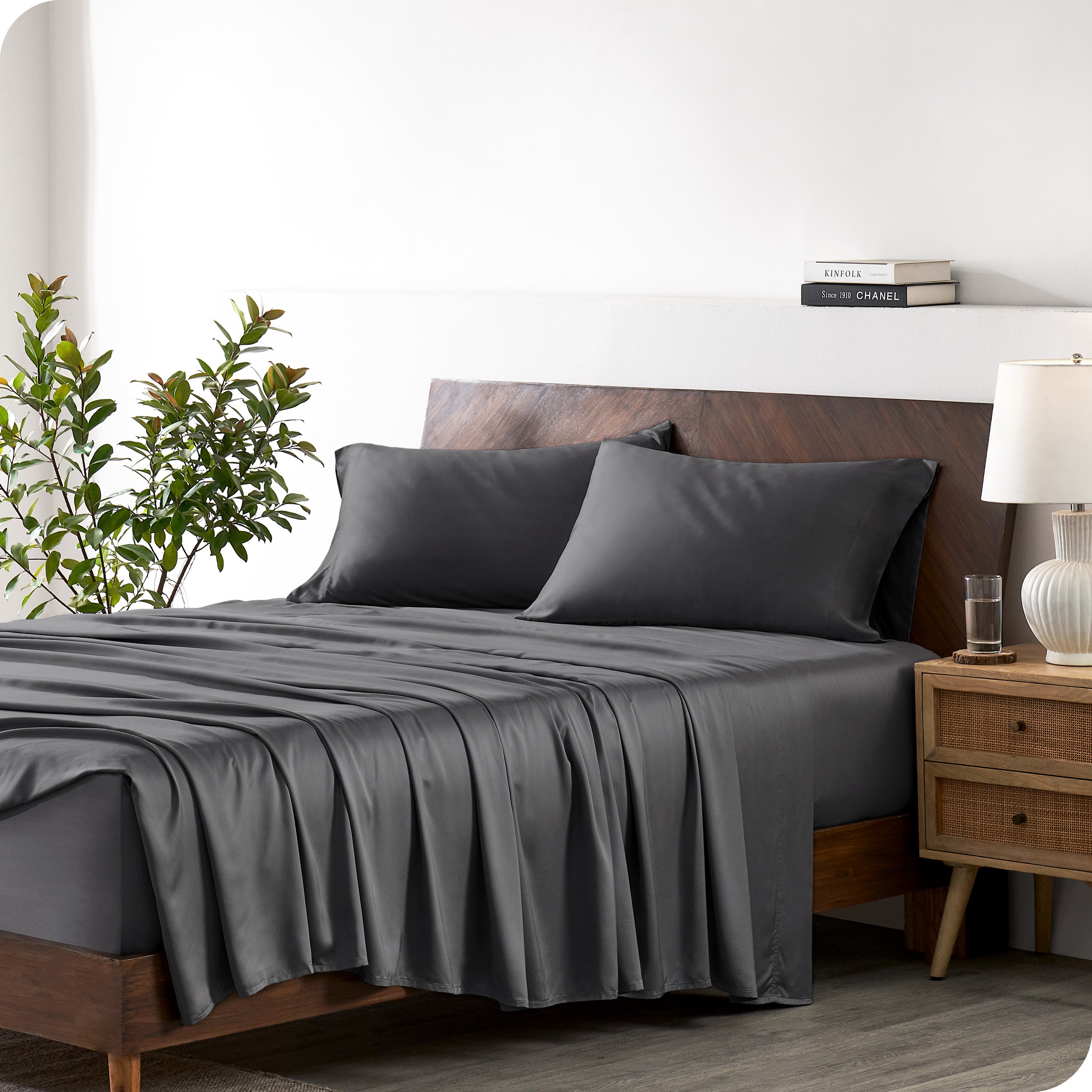 A bamboo sheet set draped over a bed with a wooden bed frame