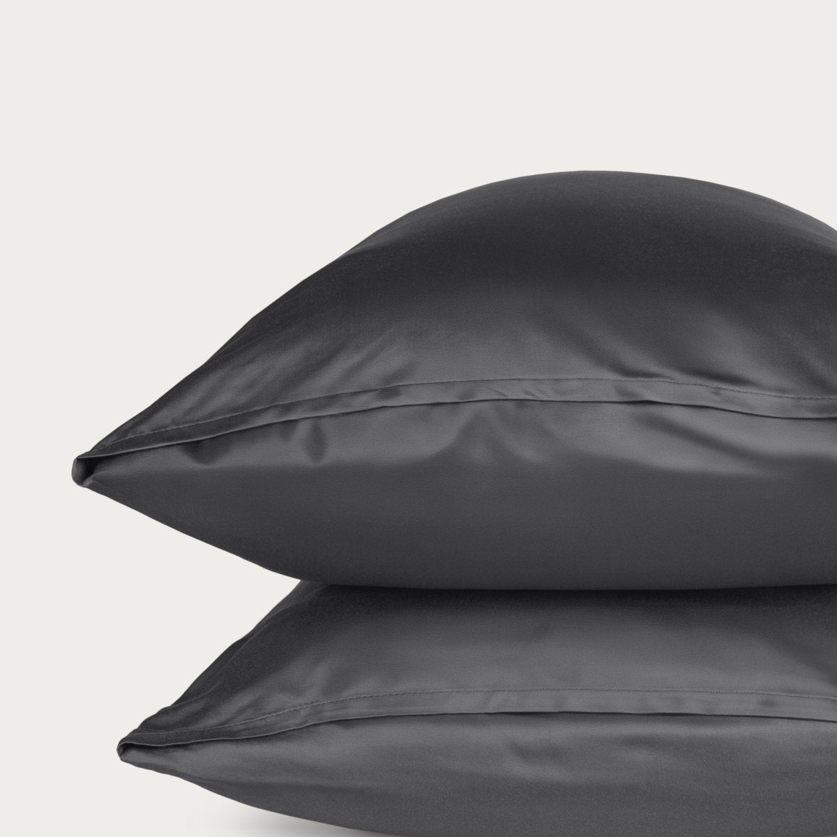 Bamboo pillowcase and bedding against a woven headboard with a plant in the corner.