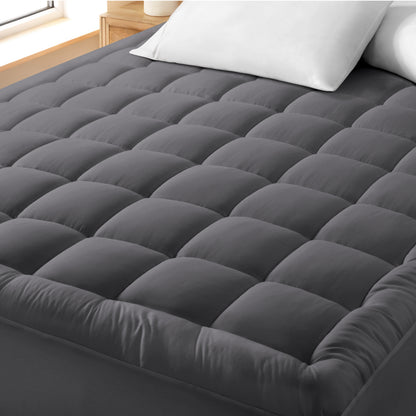 A cotton top mattress pad on a mattress in a modern bedroom.