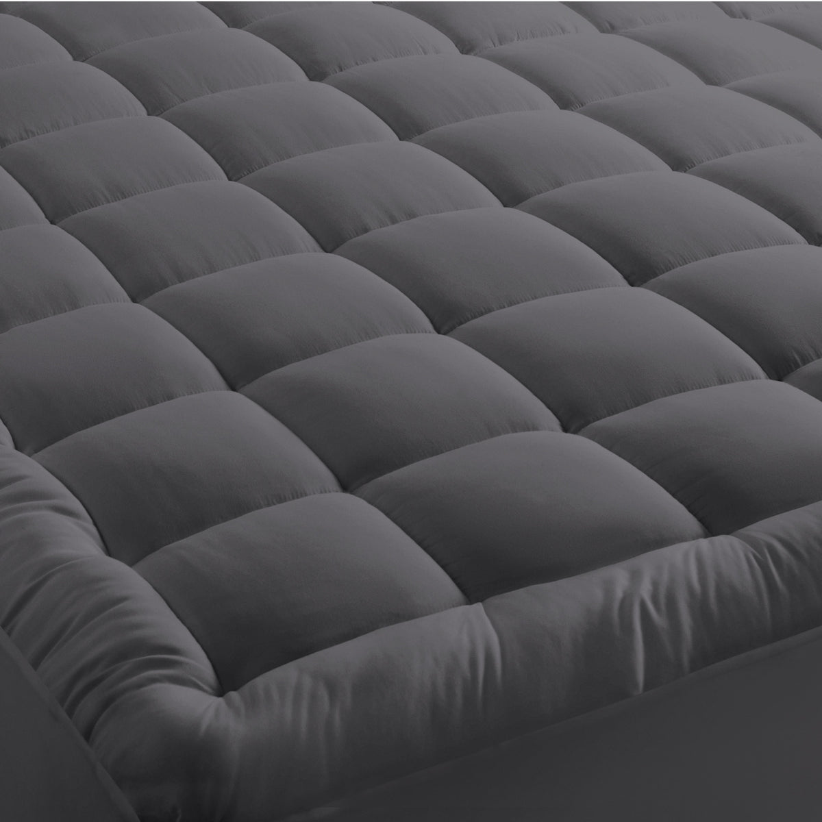 A mattress pad on a bed with 2 pillows on top