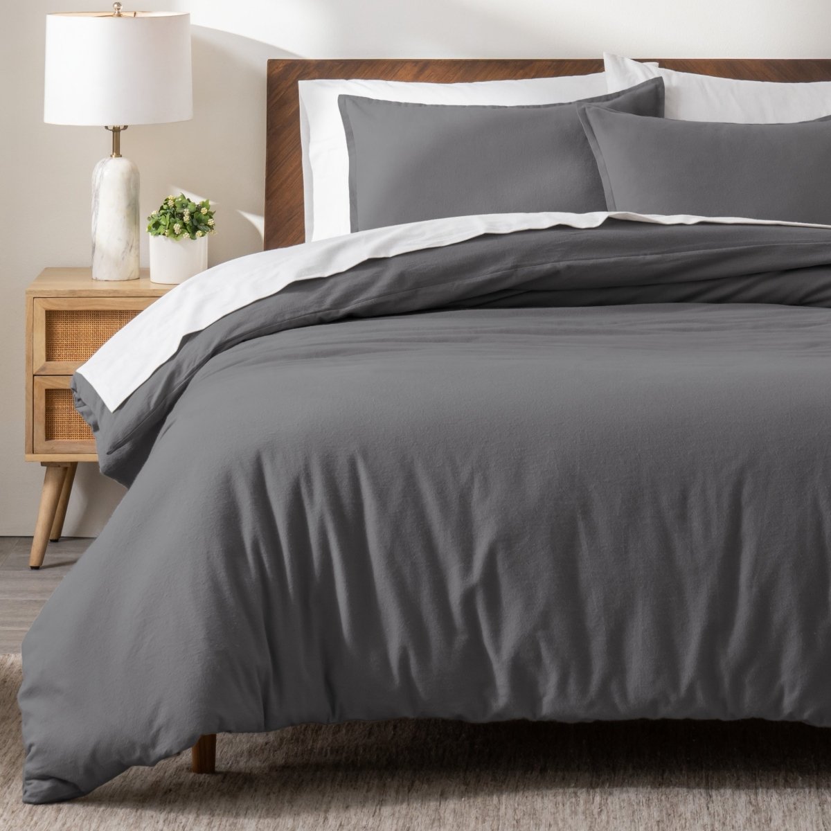 Flannel bedding set on a bed in a bedroom with a nightstand and lamp.