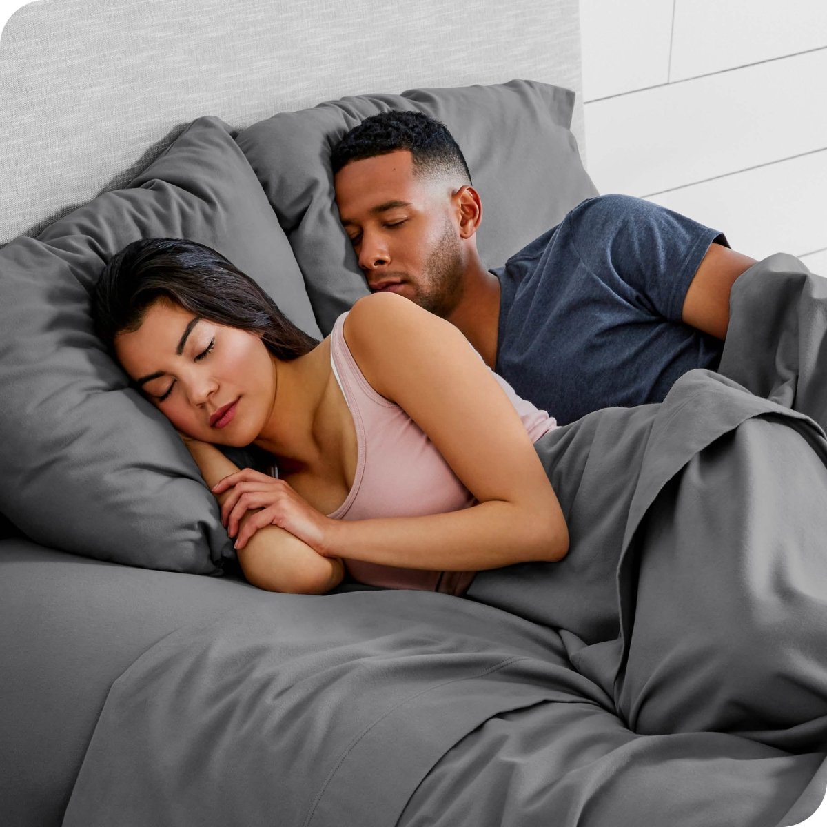 A couple sleeping with their heads resting on pillows with flannel pillowcases on them