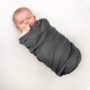 A baby swaddled in a receiving blanket