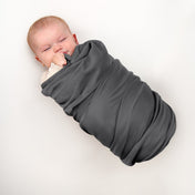 A baby wrapped in a flannel receiving blanket