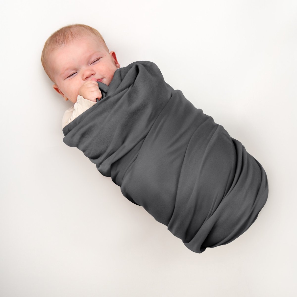 A baby wrapped in a flannel receiving blanket