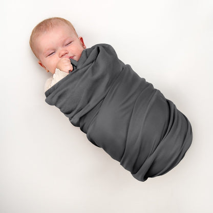 A baby wrapped in a flannel receiving blanket