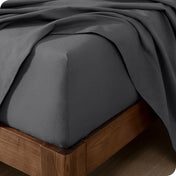 Close up of the corner of a mattress with a flannel fitted sheet and flat sheet on it