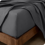 Close up of the corner of a mattress with a flannel fitted sheet and flat sheet on it