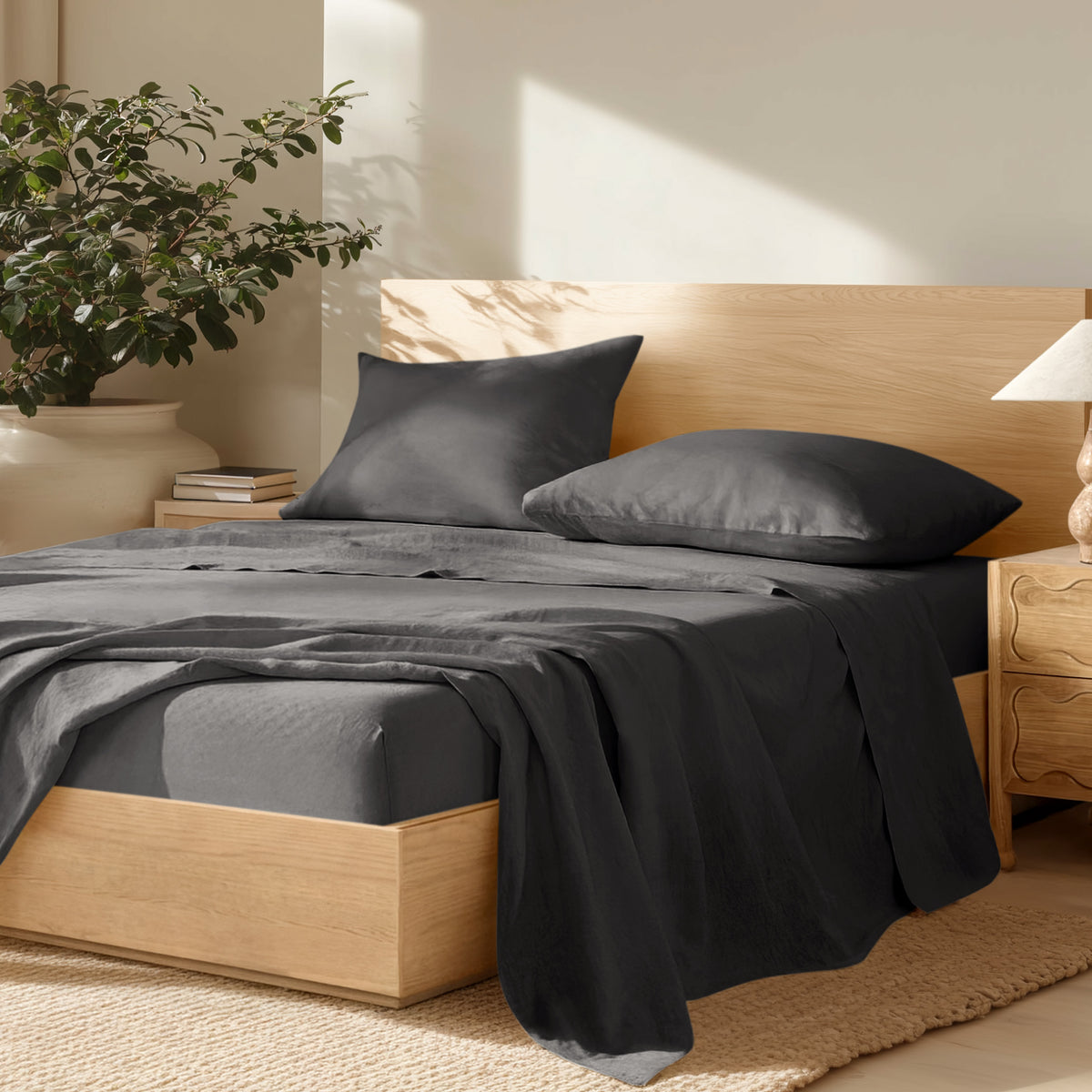 Bedroom with wooden bed frame, linen bedding, and a plant on a nightstand.