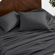 Close up of linen sheet set on a mattress with pillows inside the pillowcases