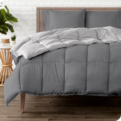 A wooden bed frame with a reversible comforter and sheet set on the mattress