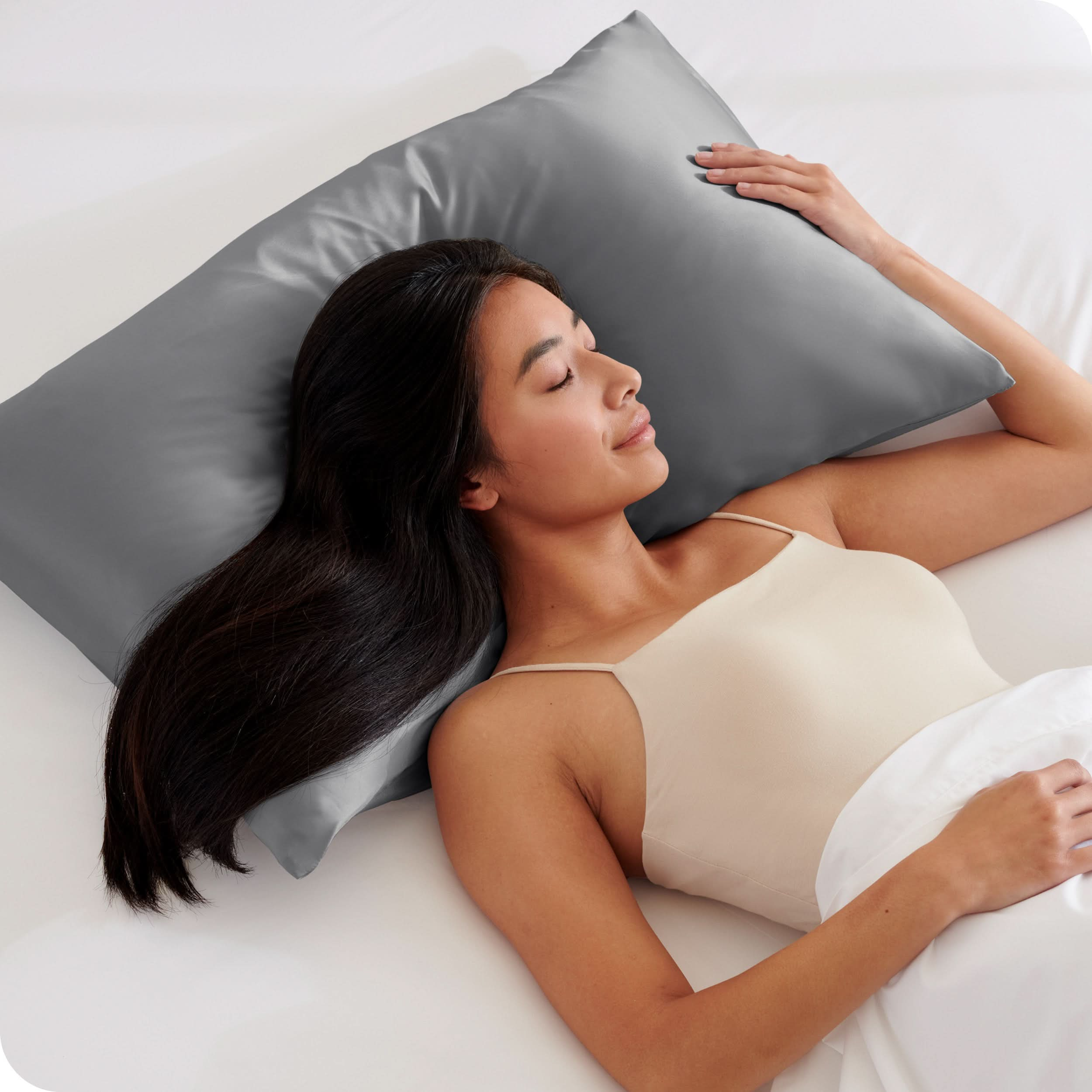 A woman is sleeping with her head on a silk pillowcase