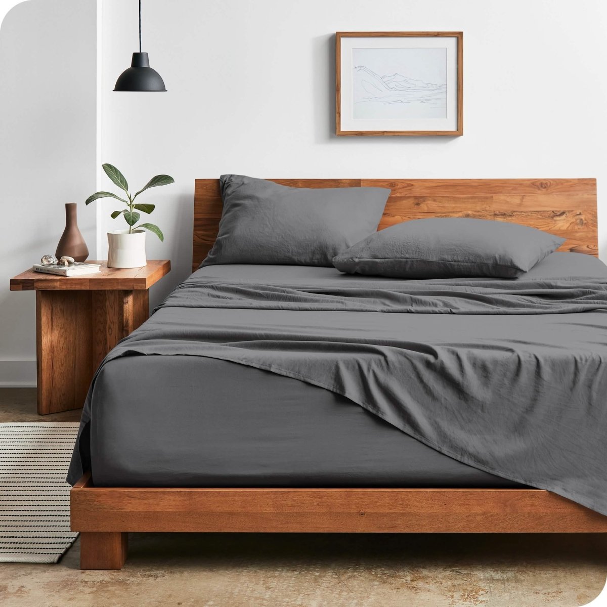 Modern bedroom with washed sheets draped over the end and the side of the bed
