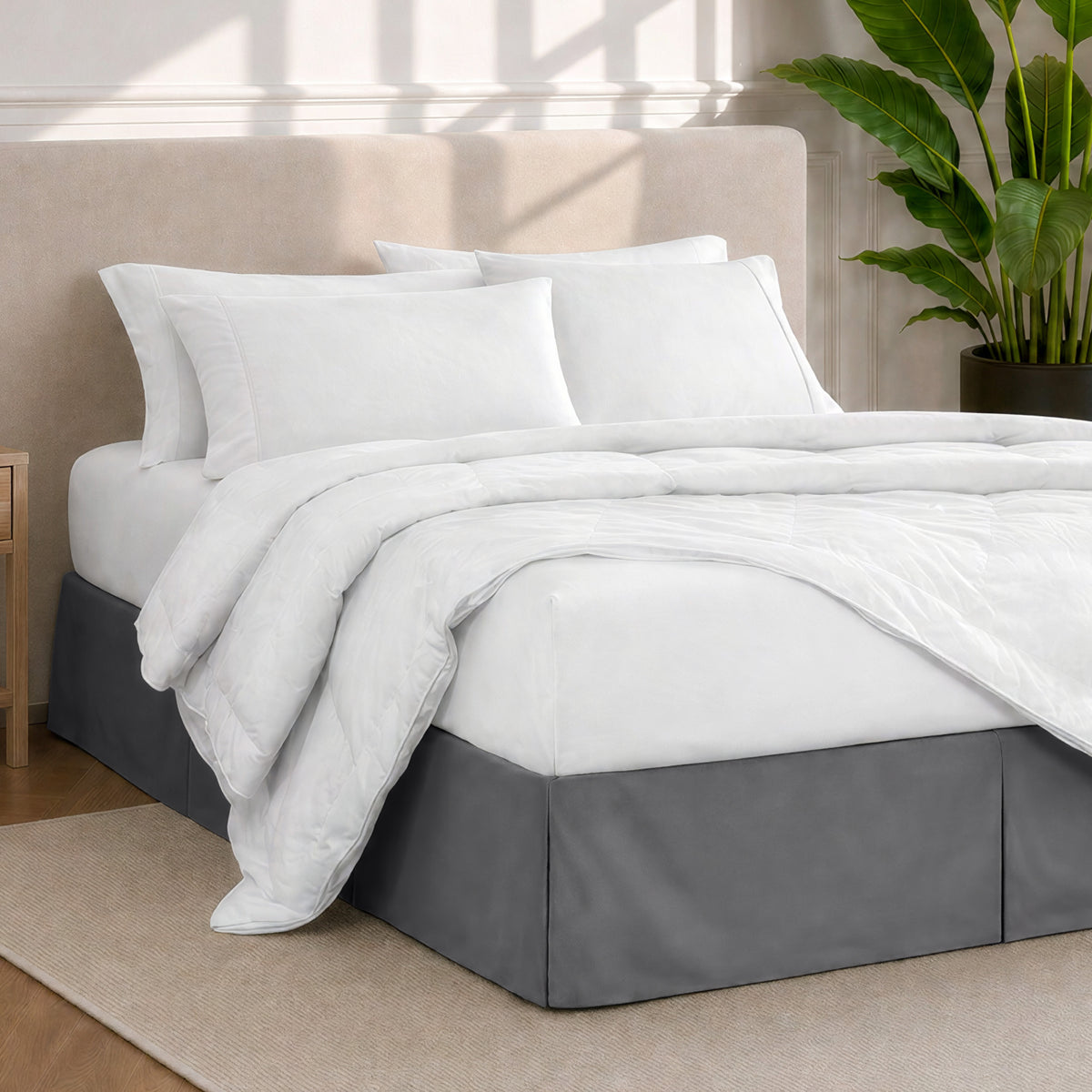A modern bedroom with a bed skirt, comforter and sheets on the bed