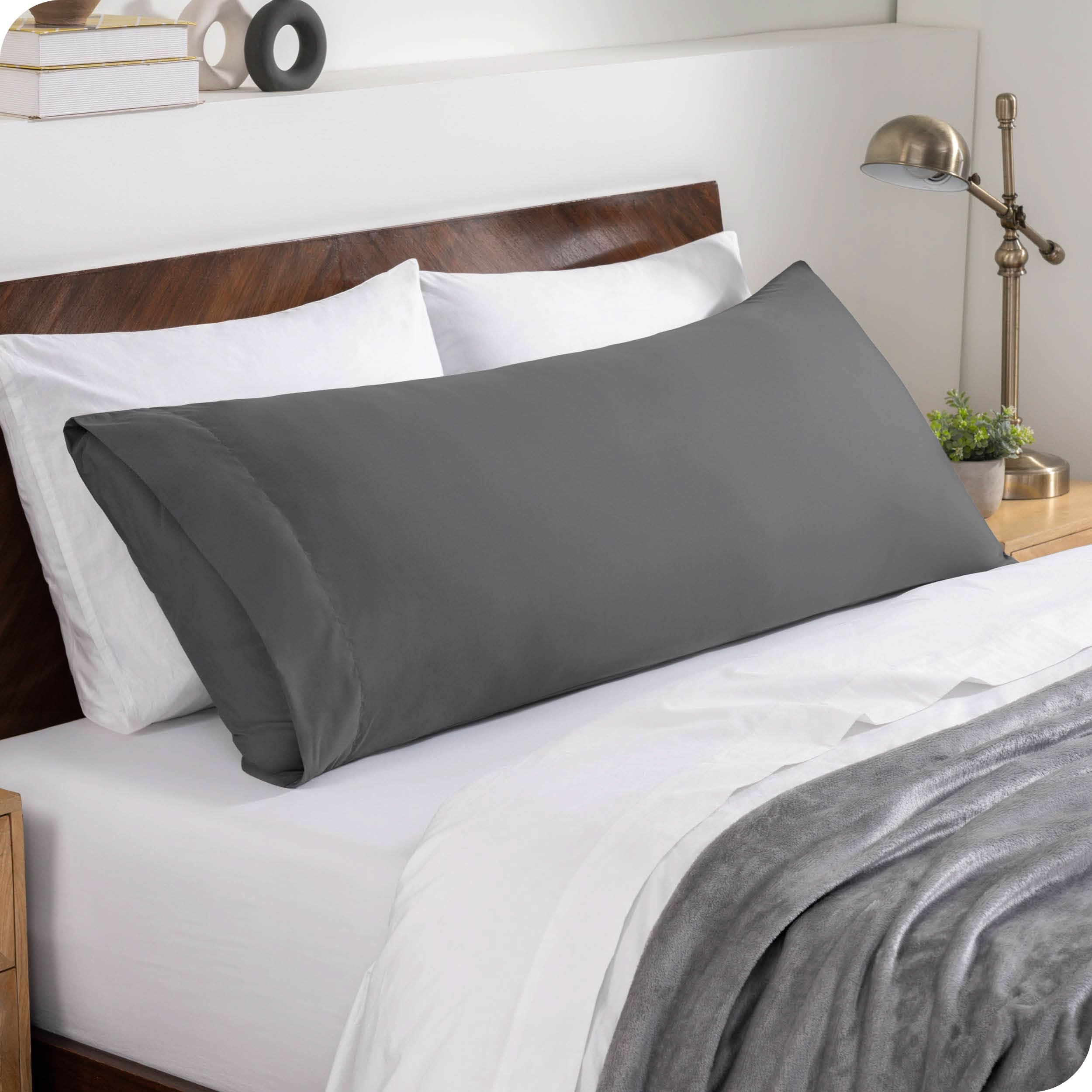 A body pillowcase on a pillow set against a headboard