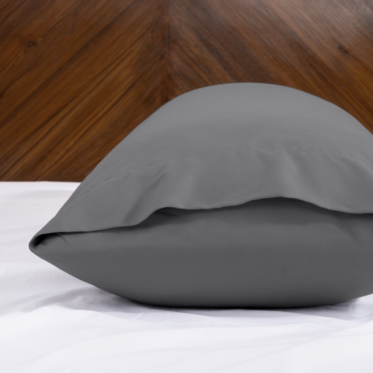 Body pillowcase with an envelope closure on a bed with a wooden headboard