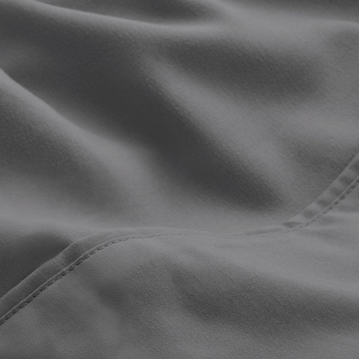 A close-up of microfiber fabric with soft folds and a visible stitched seam.
