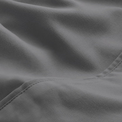 A close-up of microfiber fabric with soft folds and a visible stitched seam.